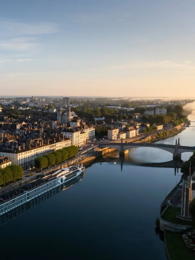 Vue aérienne de Chalon-sur-Saône au lever du soleil : la Saône, les quais, le pont Saint-Laurent et la cathédrale Saint-Vincent